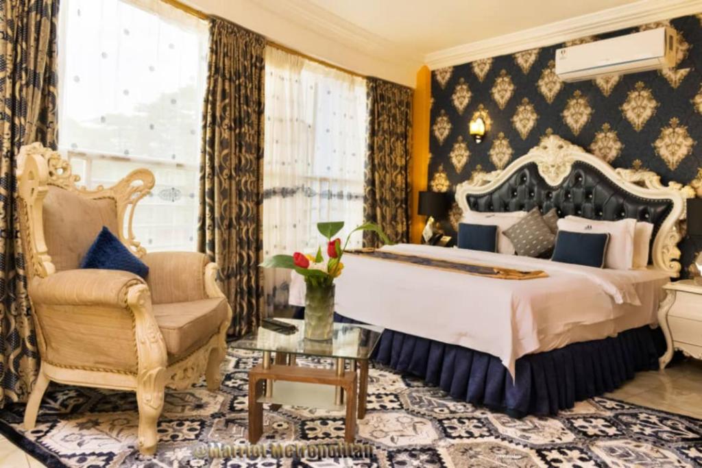 ドゥアラにあるMarriot Metropolitan Hotelのベッドルーム(キングサイズベッド1台、椅子付)