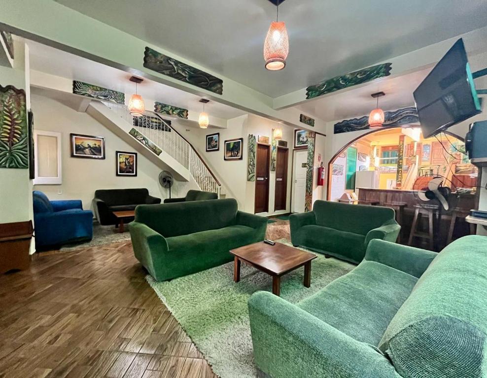 a living room with green couches and a tv at Hostel Manaus in Manaus