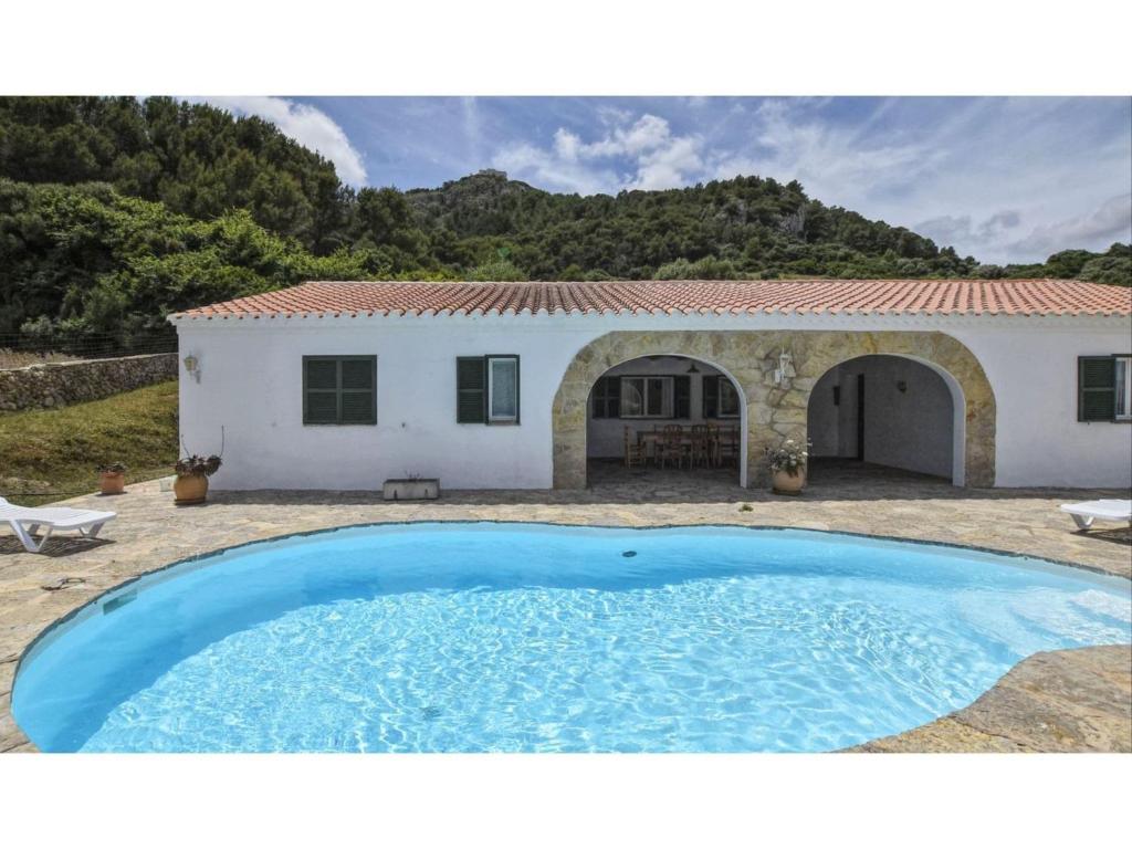 una gran piscina frente a una casa en Belvilla by OYO India Enzell, en Es Mercadal