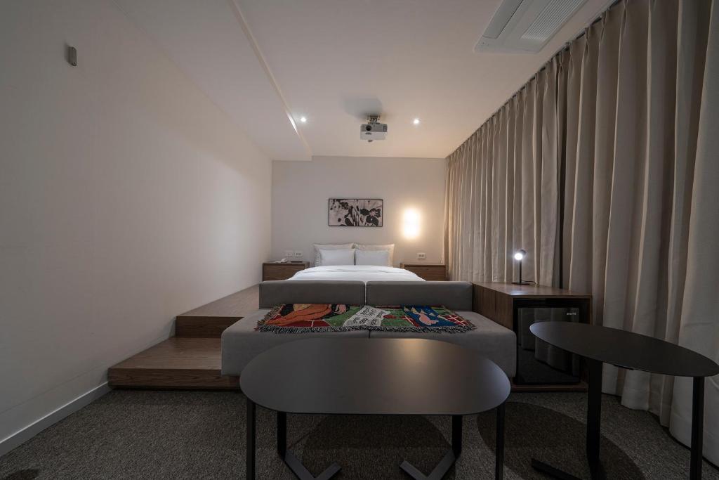 a bedroom with a bed and a table and chairs at Aank Hotel Osan in Osan