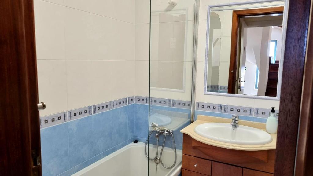 bagno con vasca, lavandino e specchio di Refúgio Do Bem Estar a Cercal