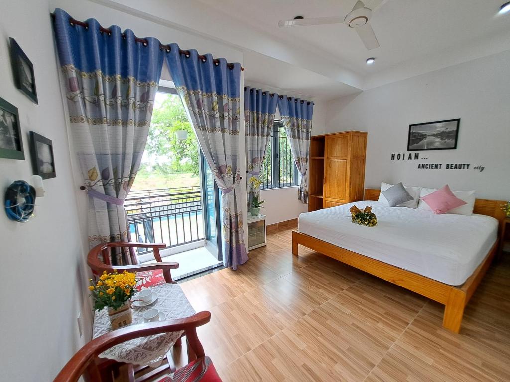 um quarto com uma cama e uma grande janela em GREEN TOWN hotel HỘI AN em Hoi An