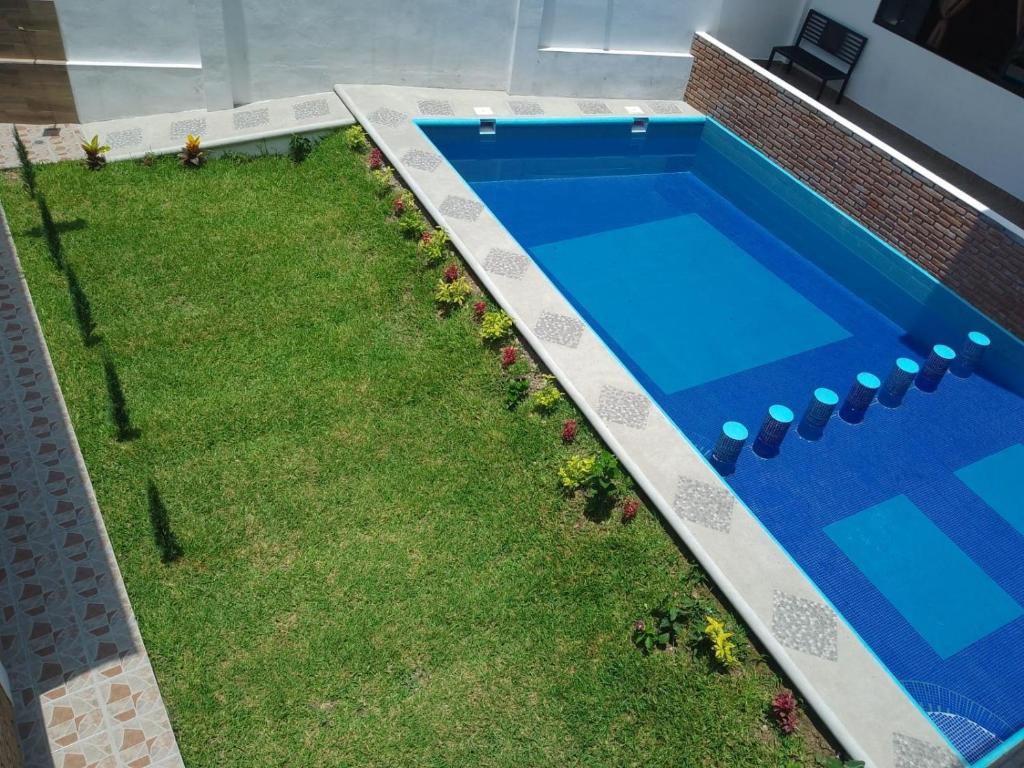 a backyard with a pool and a yard with grass at El Rincón Preferido in Papantla de Olarte