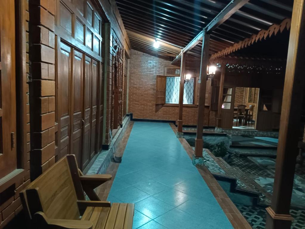 um corredor com um banco num edifício em Guesthouse Jogja Omah Punagi em Sleman