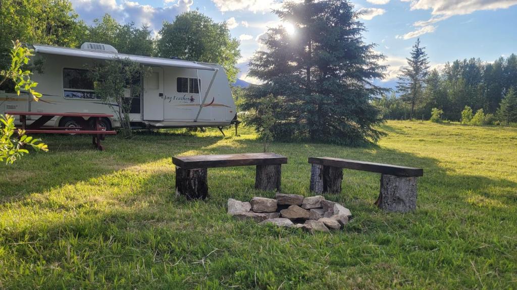 a campsite with two benches and a trailer at RV with Rocky Mountains View in McBride