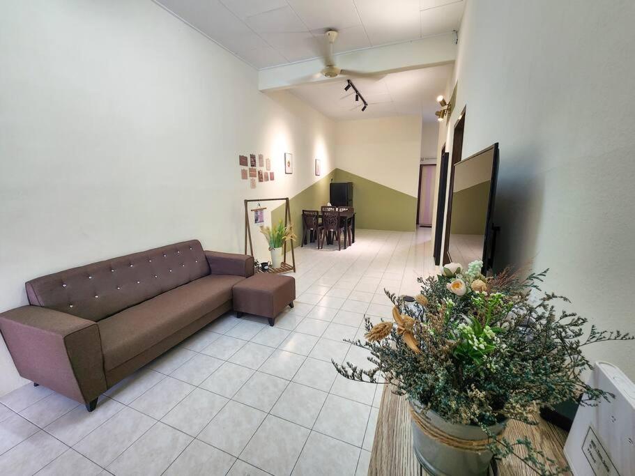 a living room with a couch and a table at Taiping Homestay Near Lakegarden in Taiping