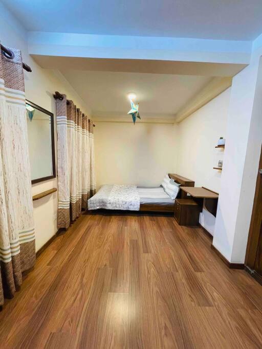 um quarto com uma cama e piso em madeira em In the heart of Patan Durbar Square em Patan