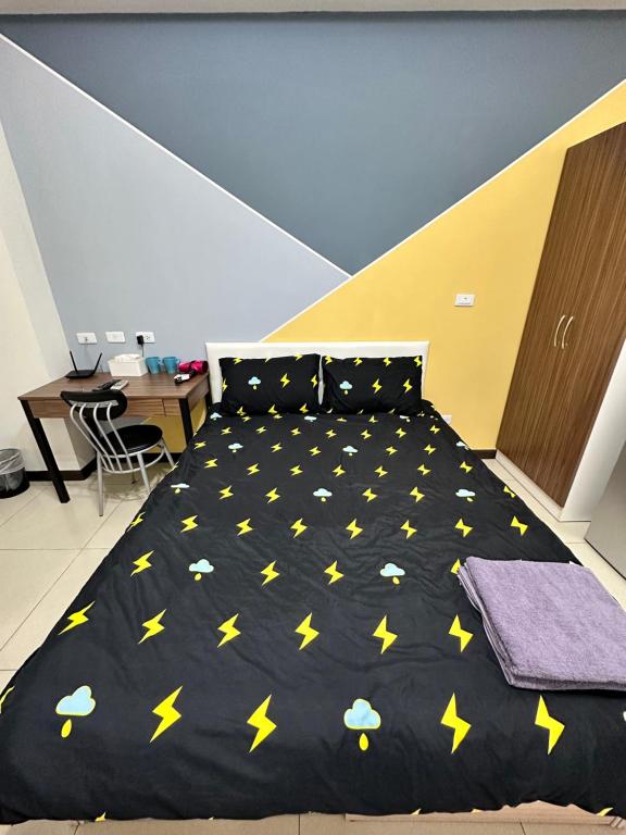 Un dormitorio con una cama negra con estrellas amarillas. en 週週客棧, en Chia-hsiu