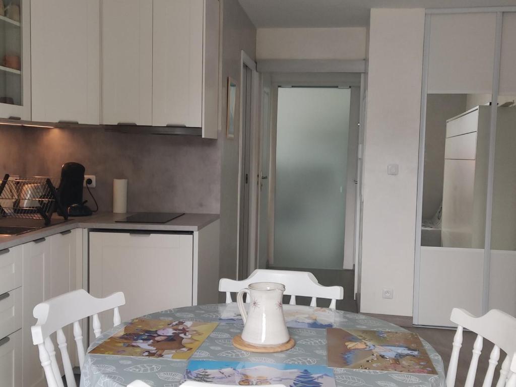 - une cuisine avec une table et un vase dans l'établissement Studio Autrans-Méaudre en Vercors-Autrans, 1 pièce, 4 personnes - FR-1-737-8, à Autrans