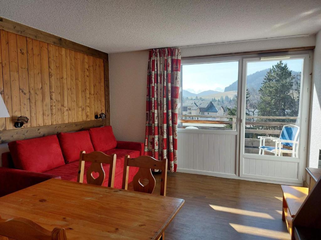 a living room with a couch and a table and a window at Appartement Autrans-Méaudre en Vercors-Autrans, 2 pièces, 4 personnes - FR-1-737-24 in Autrans
