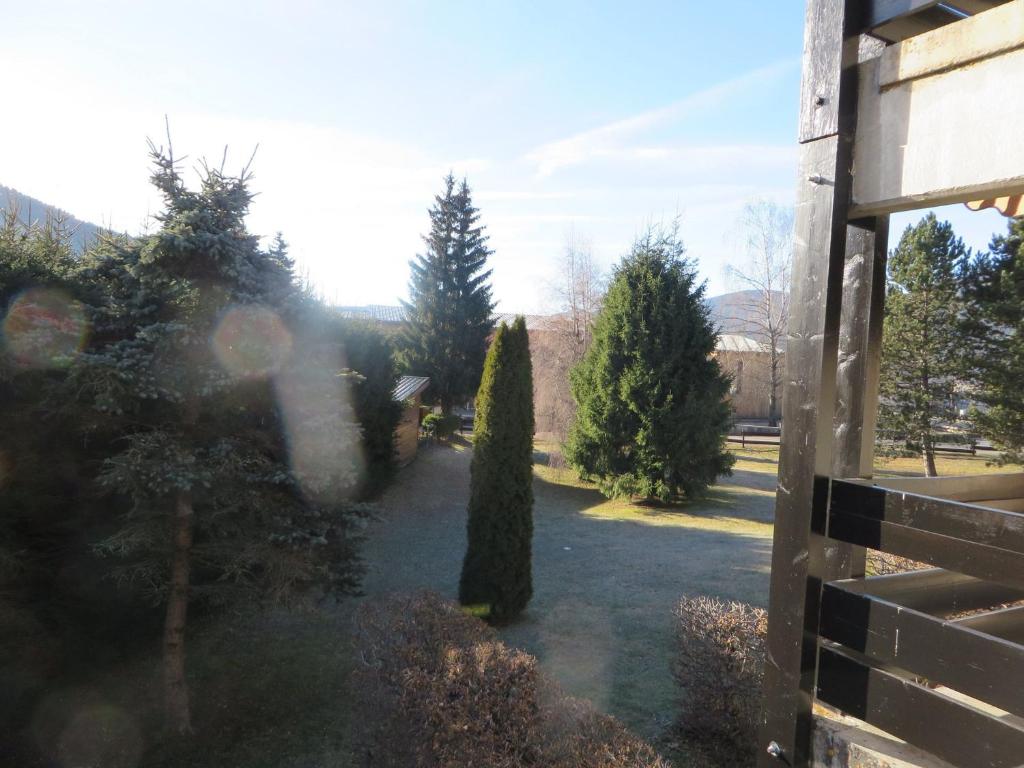 a view of a yard with trees and a fence at Studio Autrans, 1 pièce, 3 personnes - FR-1-737-33 in Autrans