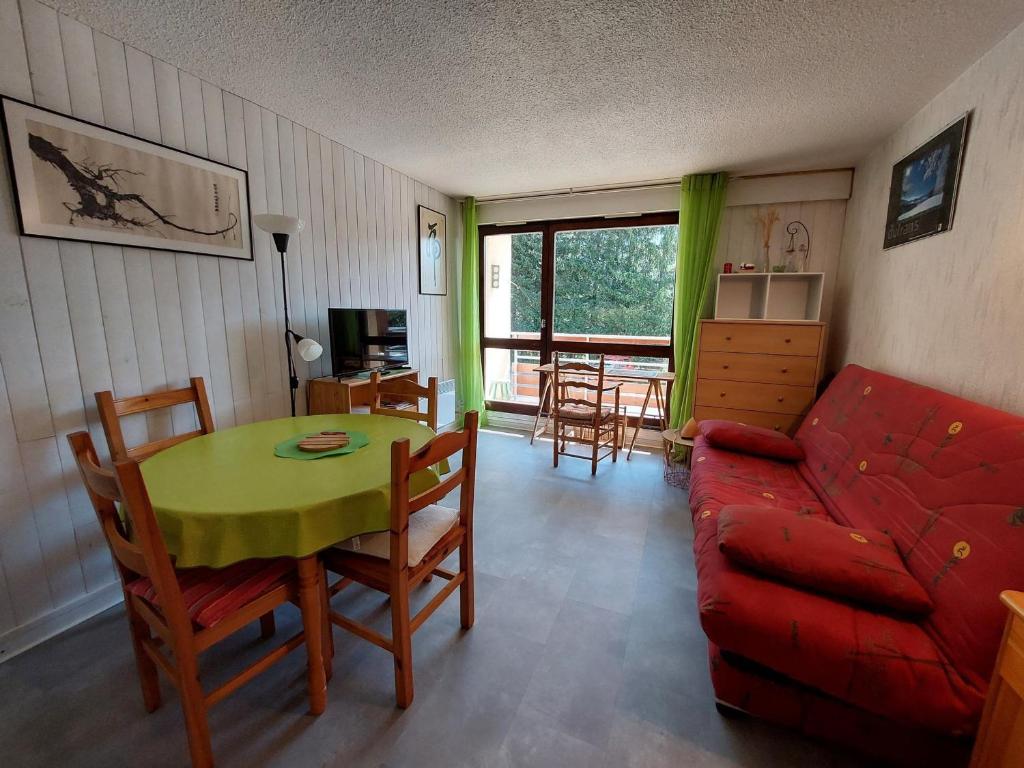 a living room with a red couch and a table at Appartement à Autrans, 39m², 6 pers, proche pistes et village, balcon est, parking privé - FR-1-737-42 in Autrans