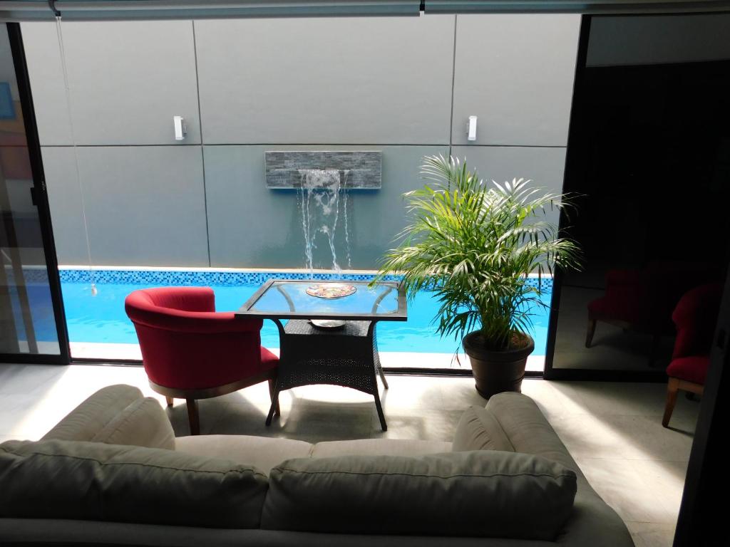 Una sala de estar con un sofá, una mesa y una fuente. en Oasis Urban Retreat, en Cancún
