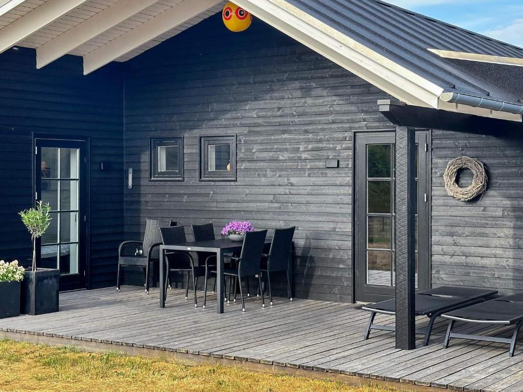 une terrasse avec une table et des chaises sur une maison dans l'établissement 6 person holiday home in Hadsund, à Hadsund