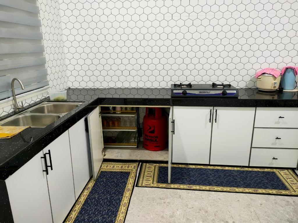 a small kitchen with a sink and a refrigerator at Homestay D Twinz (2 unit semi d) in Kuala Berang