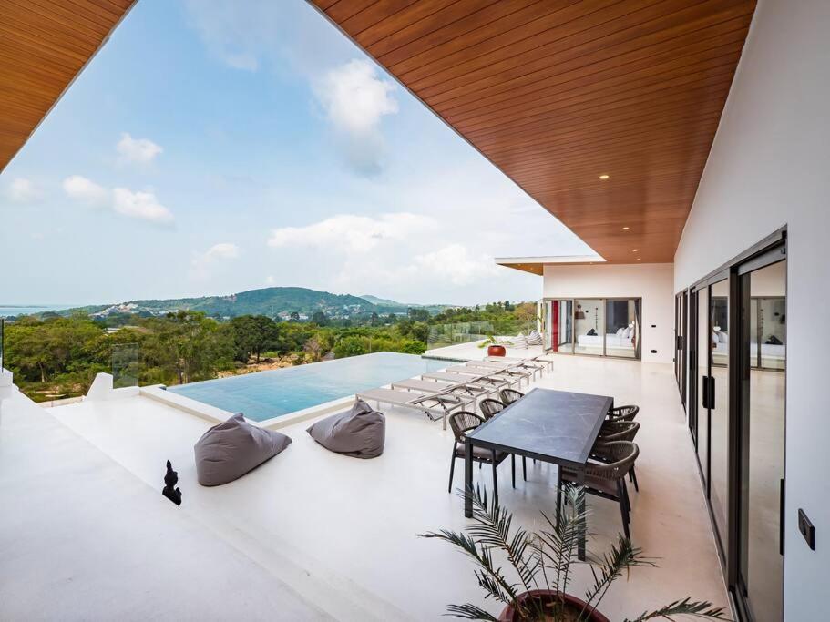 un patio avec une table et des chaises et une piscine dans l'établissement Villa Dila 3 bed Elephant Haven!, à Koh Samui 
