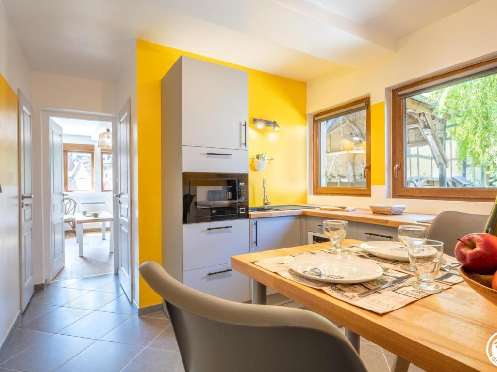 eine Küche mit gelben Wänden und einem Holztisch in der Unterkunft Gîte Loueuse, 2 pièces, 3 personnes - FR-1-526-36 