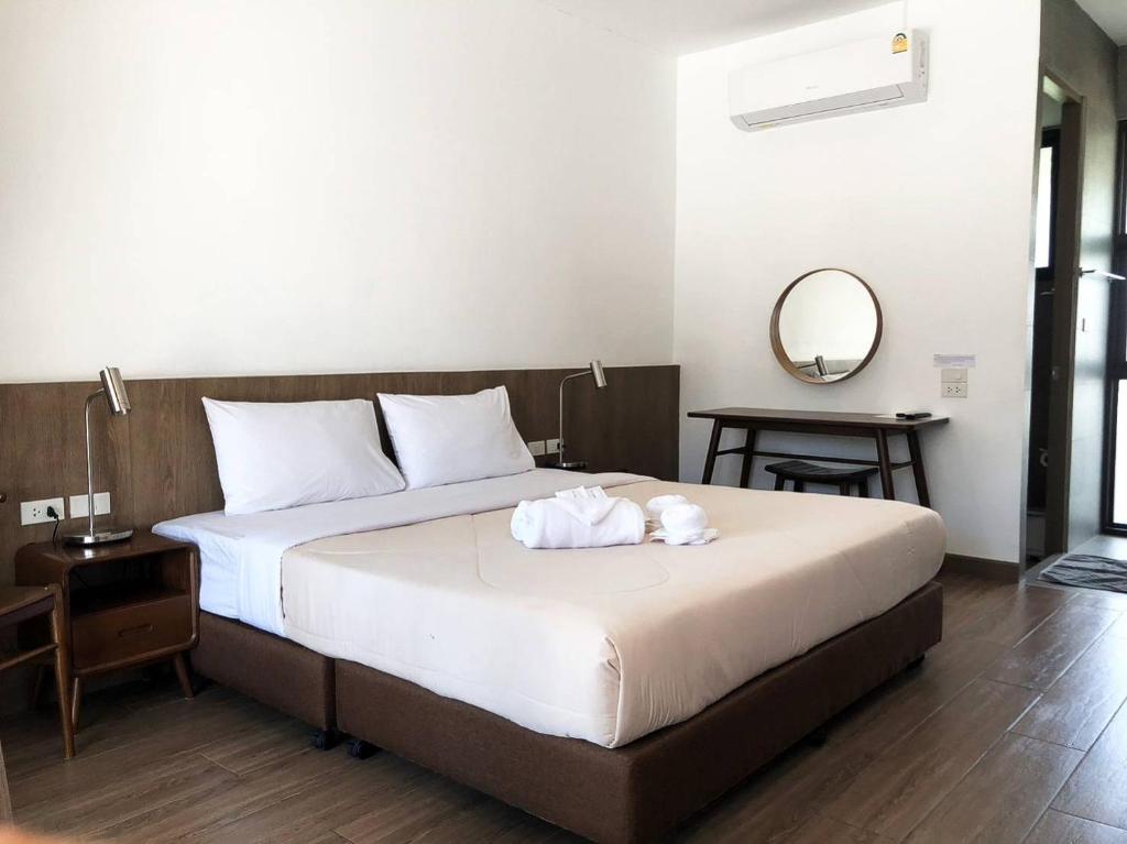 um quarto de hotel com uma cama com toalhas em Suansin Garden Hotel โรงแรมสวนสินการ์เด้น em Tak