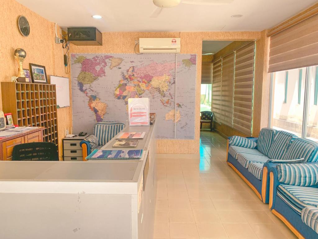 um quarto com duas cadeiras azuis e um mapa na parede em Amzar Motel Cenang em Pantai Cenang