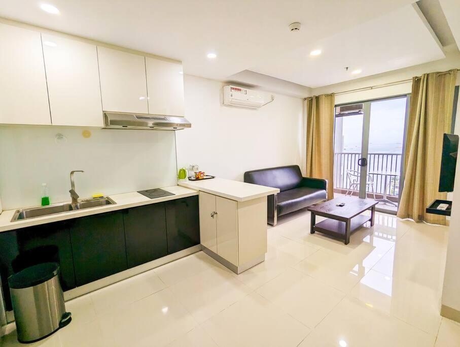 a kitchen with a sink and a couch in a room at Lovina 1811 Harbourbay Residence in Batu Ampar