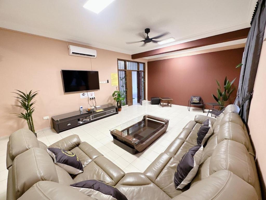 sala de estar con sofá de cuero y TV en B04 Modern Deluxe Homestay, en Johor Bahru