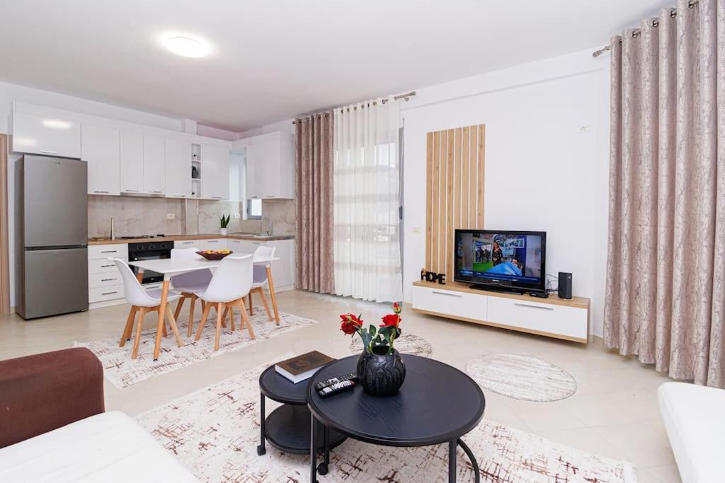 a living room with a couch and a table at Stylish City Apartment in Vlorë