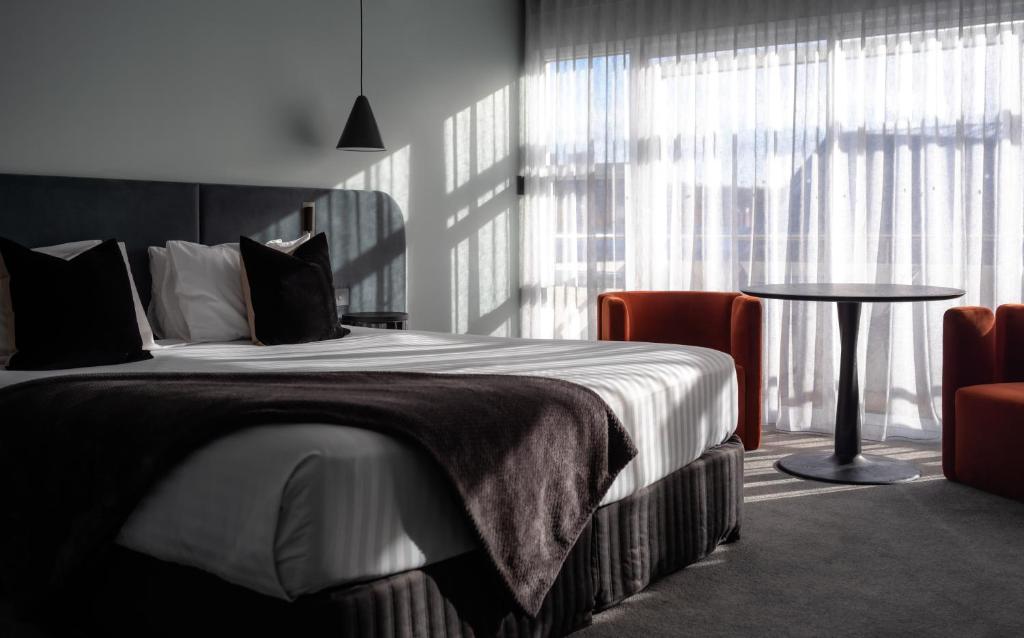 a bedroom with a bed and a table and a window at Salamanca Suites in Hobart