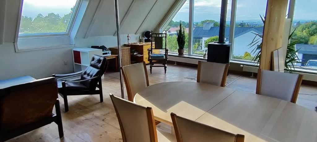 Habitación con mesa, sillas y ventanas. en Værelse med egen stue, en Horsens