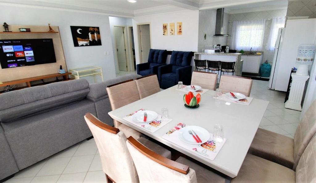 - un salon avec une table blanche et un canapé dans l'établissement 1010 - Residencial Solar das Bromélias Apto 233, à Bombinhas