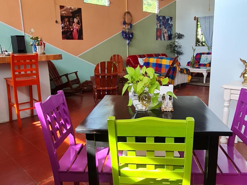 uma sala de jantar com uma mesa e cadeiras coloridas em Hostal tortuga viajera em Moyogalpa