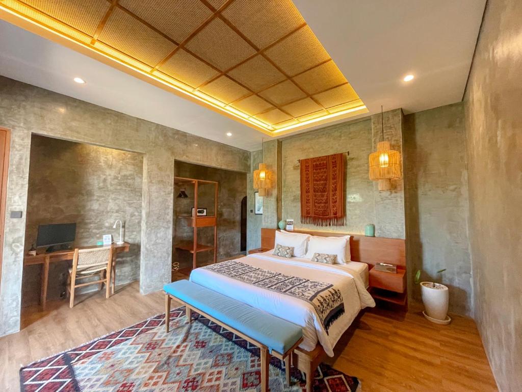 una camera da letto con un letto con una panca blu di Leafy Home Canggu a Canggu