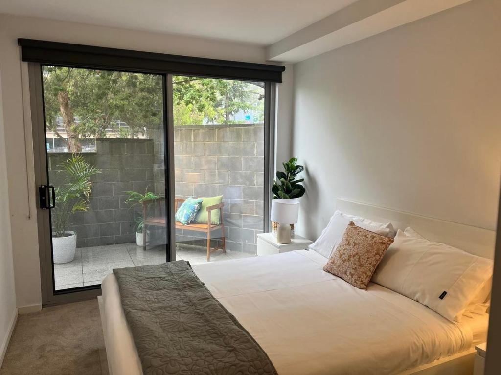 a bedroom with a bed and a large window at Centrepoint Units Heidelberg in Melbourne