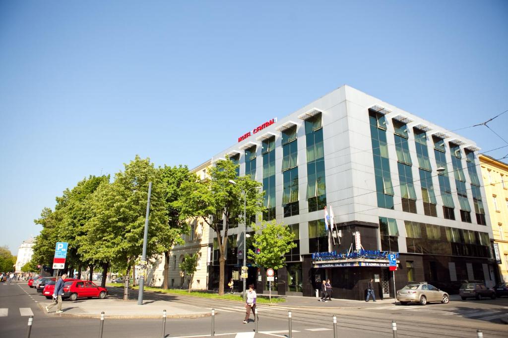 - un grand bâtiment blanc dans une rue de la ville dans l'établissement Hotel Central, à Zagreb