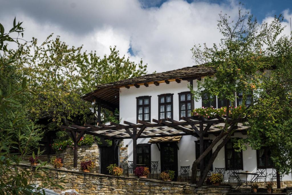 una casa blanca con pérgola en Dedovite Kashti, en Stefanovo