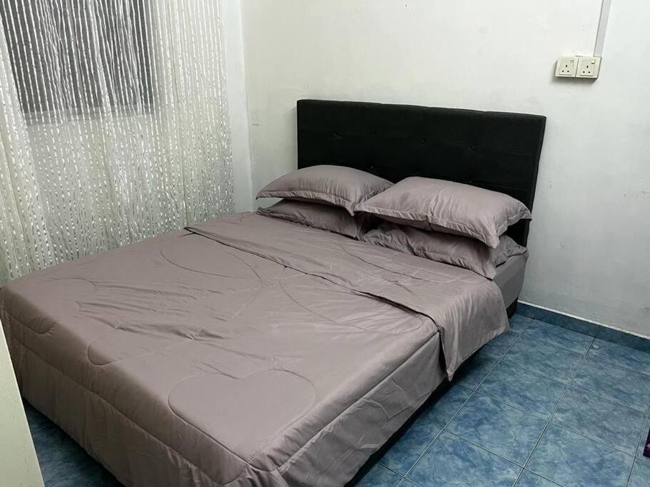 a bed in a room with a large bed with pillows at Manjung Modern + Cozy Terrace Home in Lumut