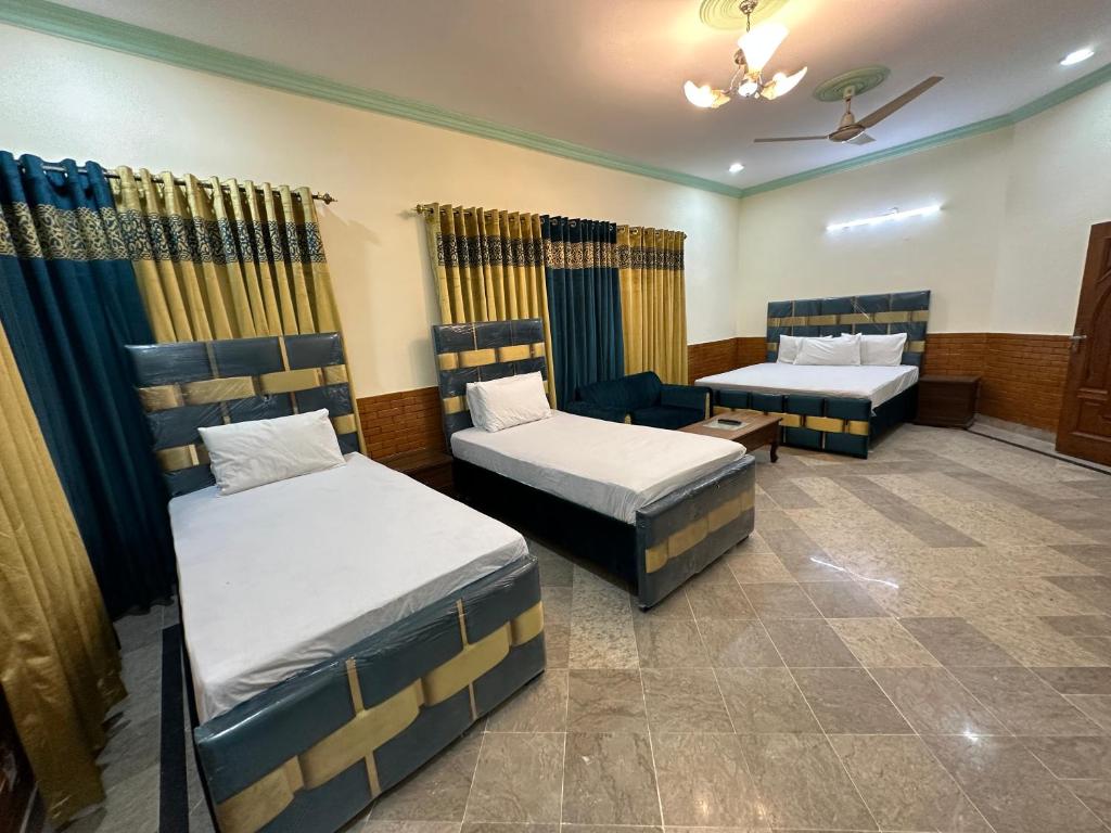 Habitación con 2 camas y sofá en Decent Lodge Guest House F-11 en Islamabad