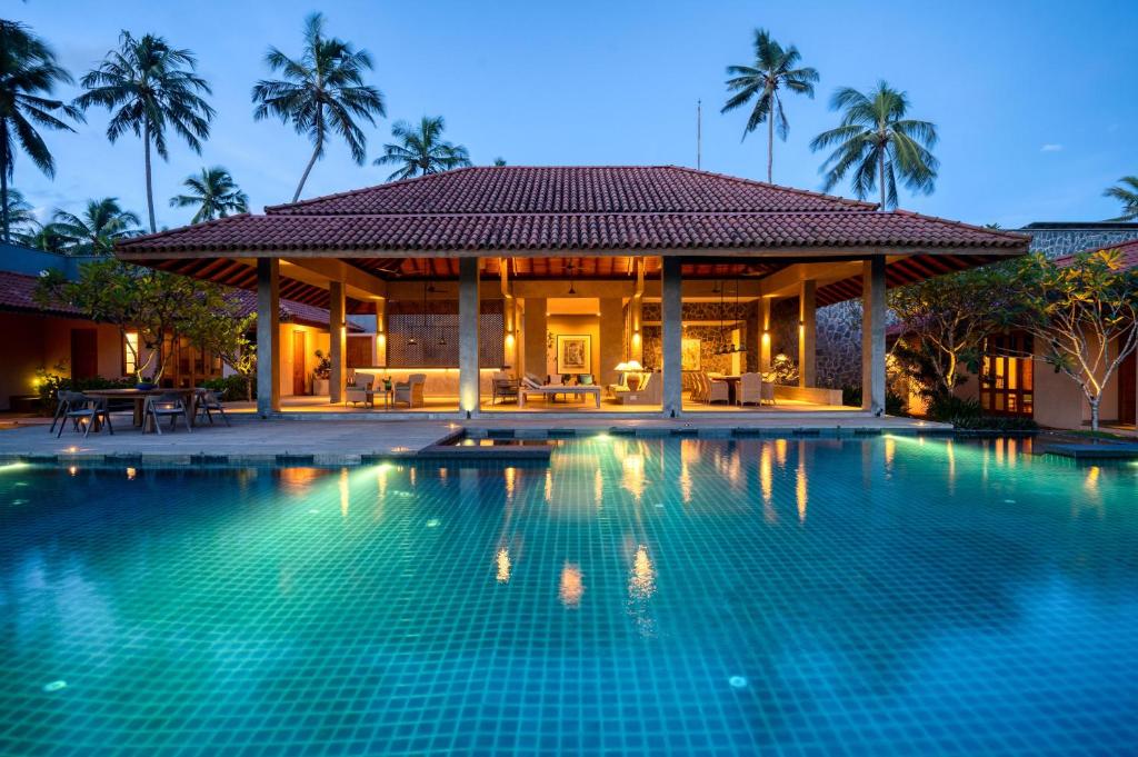 a villa with a swimming pool at night at Kirana - A Santani Villa in Bentota