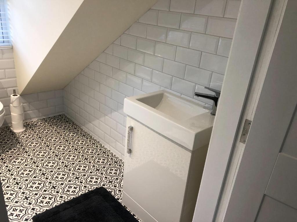 a bathroom with a sink and a tiled floor at Kirkcudbright Holiday Apartments - Apartment G in Kirkcudbright