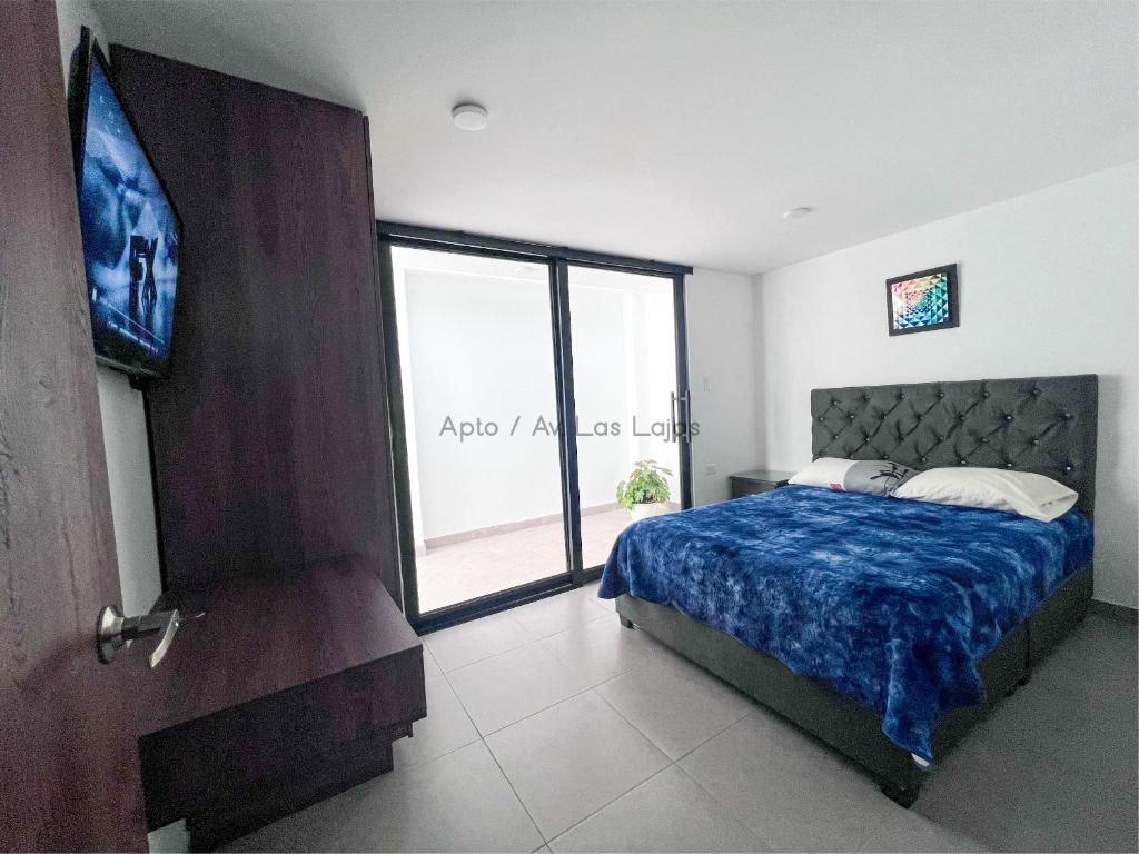 a bedroom with a bed and a large window at Apto Av Las Lajas in Ipiales