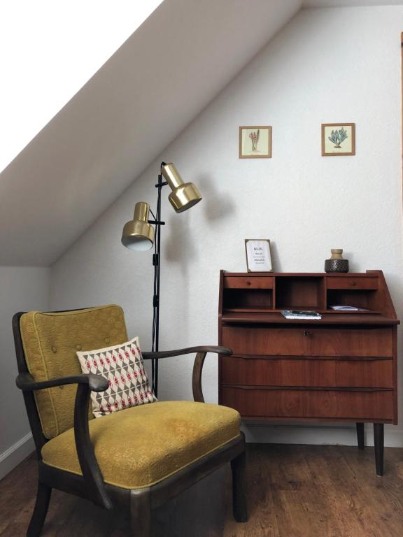 a room with a chair and a desk and a lamp at Gården på Bakken in Holme-Olstrup