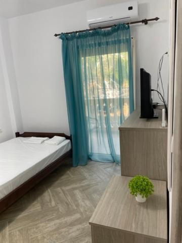 a bedroom with a bed and a window with a television at Apartment Nikolay in Nea Potidaea