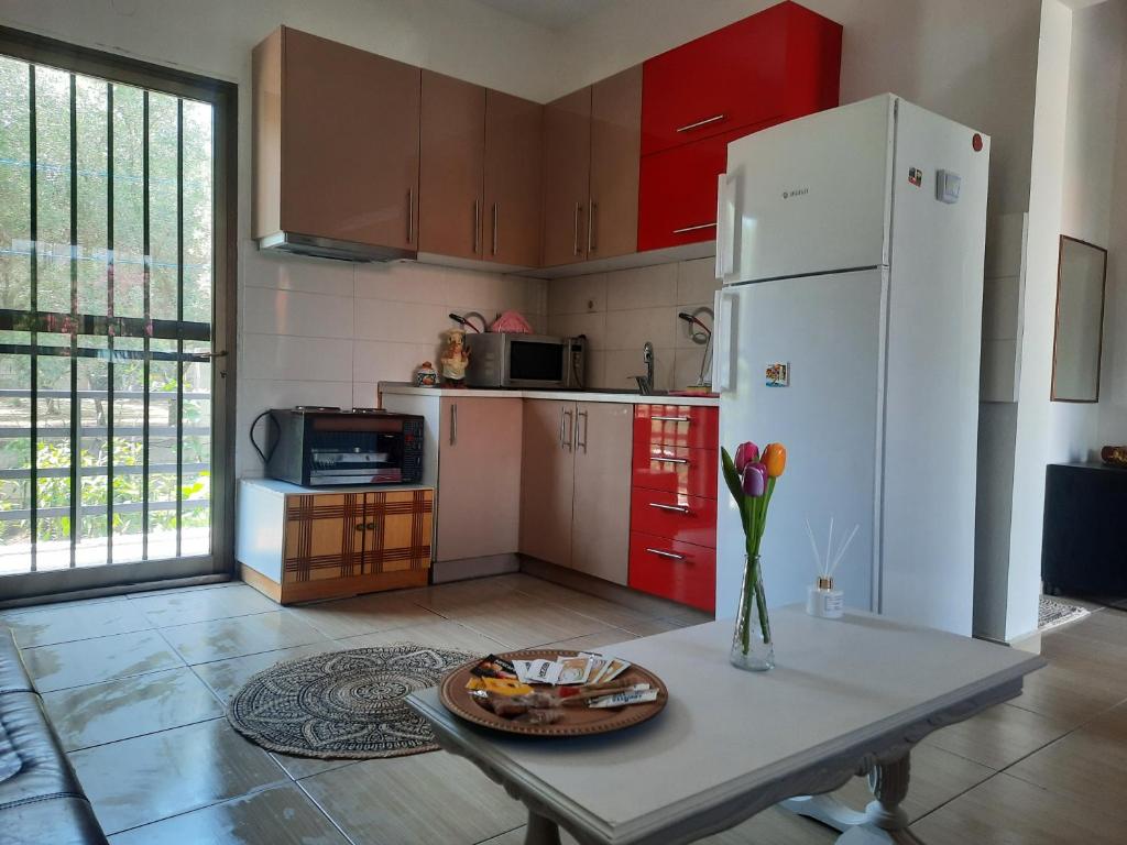 a kitchen with a table and a white refrigerator at Think Blue Apartment in Nea Vrasna in Asprovalta
