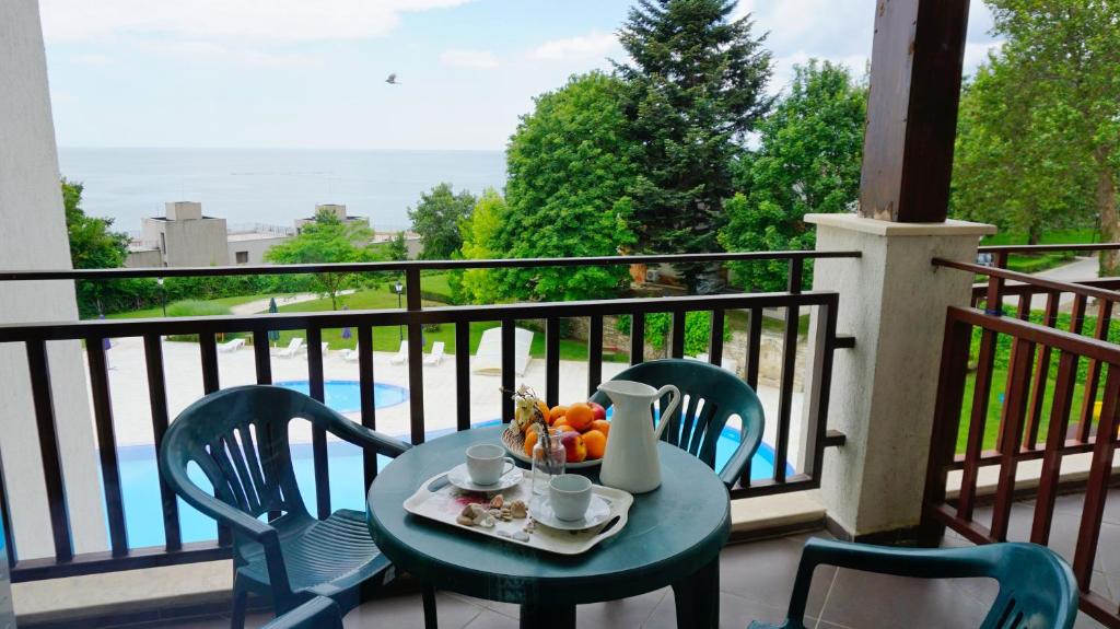 uma mesa com uma tigela de fruta numa varanda em Апартамент Балчик Гардънс - Balchik Gardens Apartment em Balchik