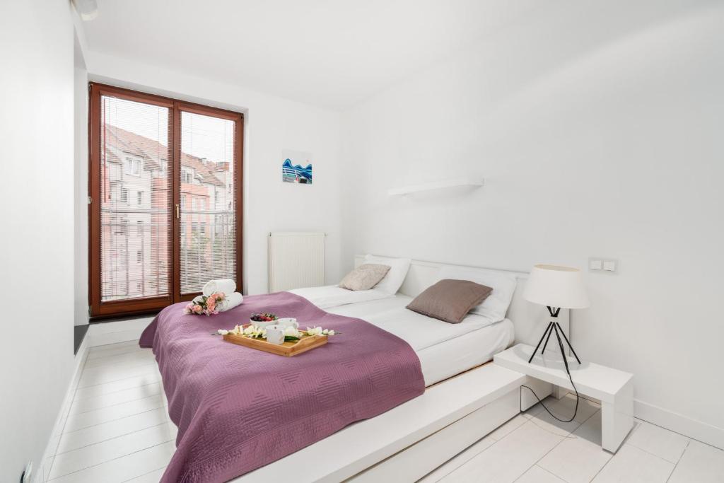 een witte slaapkamer met een bed met een dienblad erop bij Modern Minimalism Apartment near Poznań Old Market by Renters in Poznań