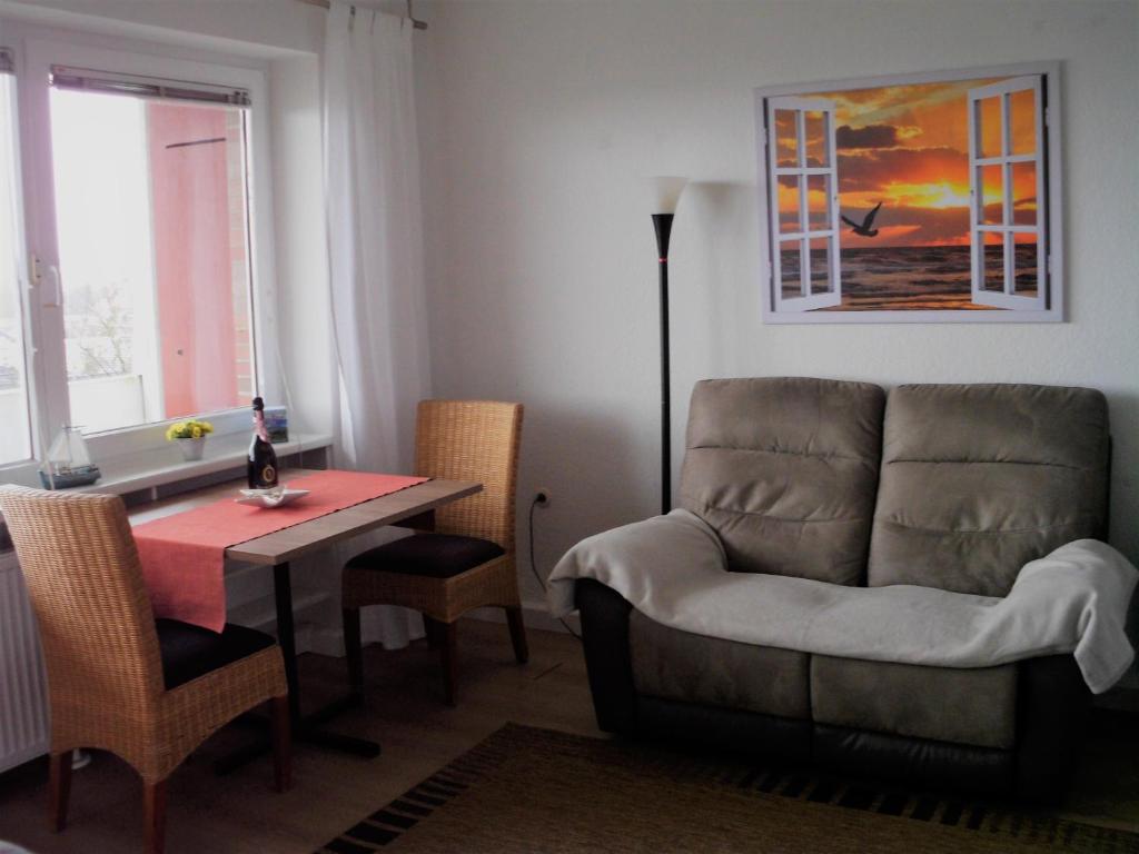 a living room with a couch and a table at Tief 10 Wohnung 408 in Wangerland