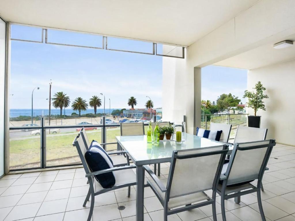 comedor con mesa y sillas y ventana grande en Relax in Style Comfort, en Victor Harbor