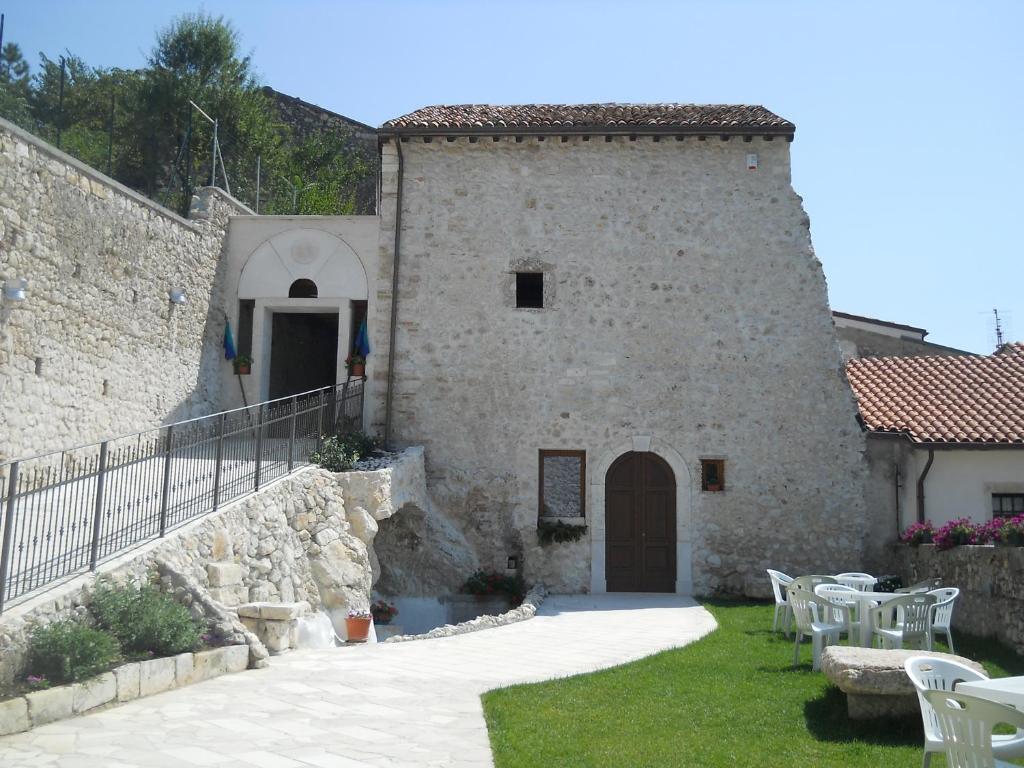 a stone building with tables and chairs in a yard at Locanda Incantata Room & Relax in Scurcola Marsicana