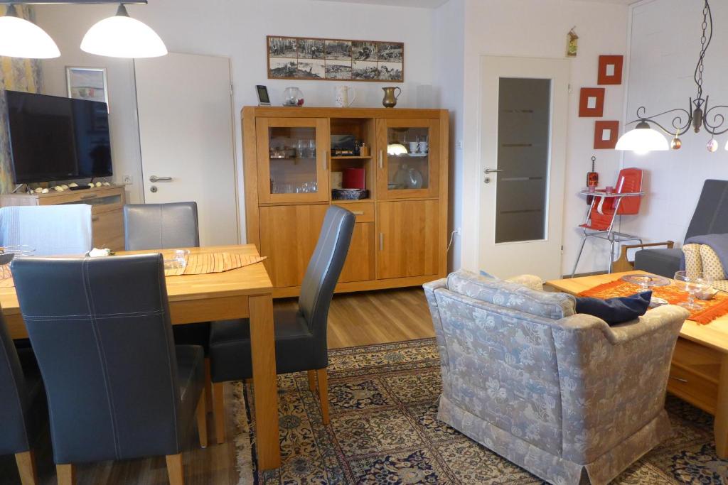 Una sala de estar con mesa de comedor y sillas. en Tief 10 Sandburg 104, en Wangerland