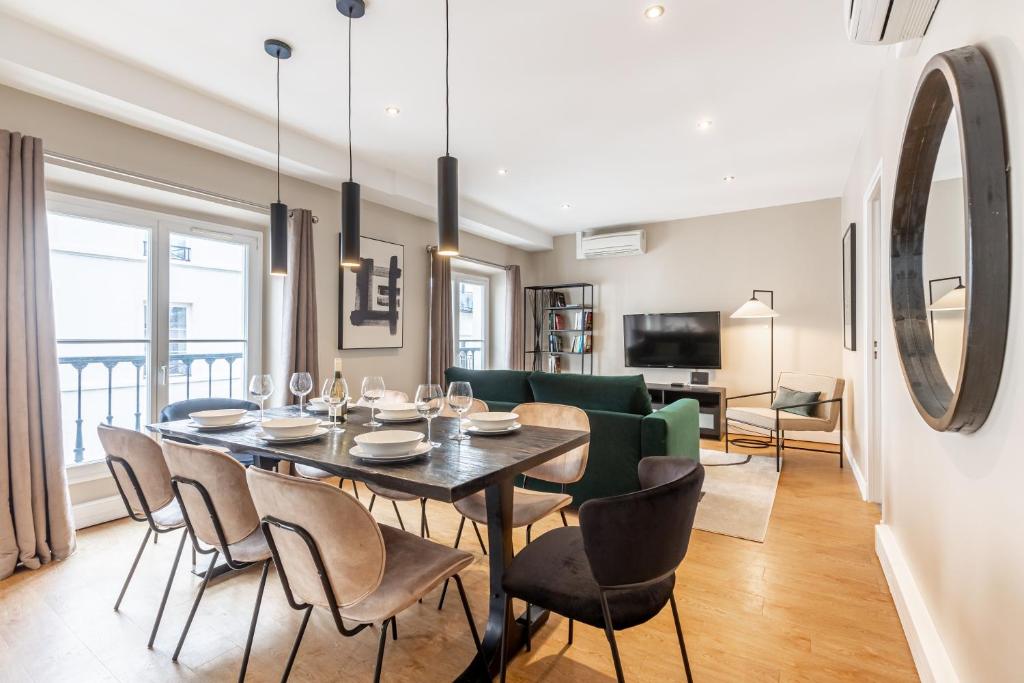 une salle à manger et un salon avec une table et des chaises dans l'établissement Sweett - Pavillon Opera, à Paris