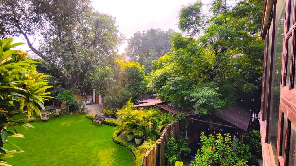 un cortile con un cortile verde con panchine e alberi di Cp Villa - Rooms with Patio a Nuova Delhi